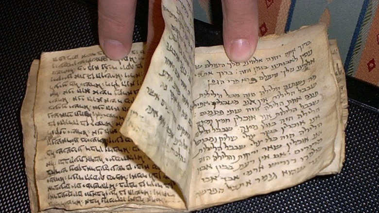  siddur being held open two fingers