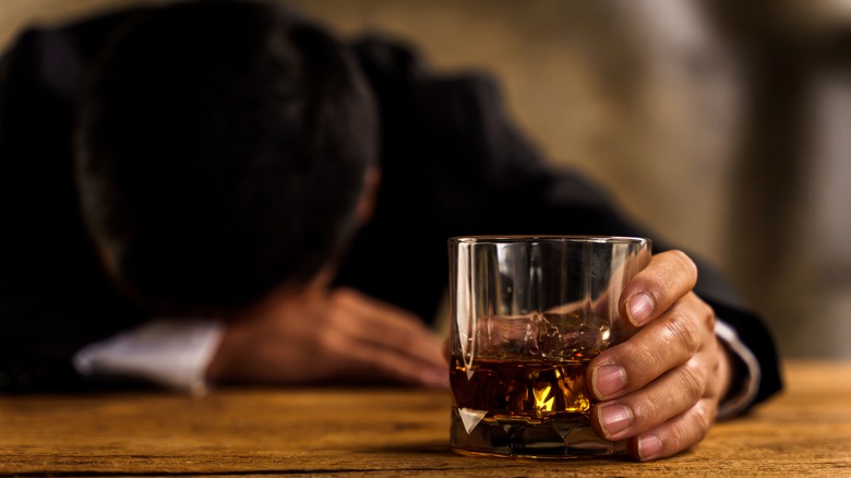 guy asleep on the table glass of whiskey