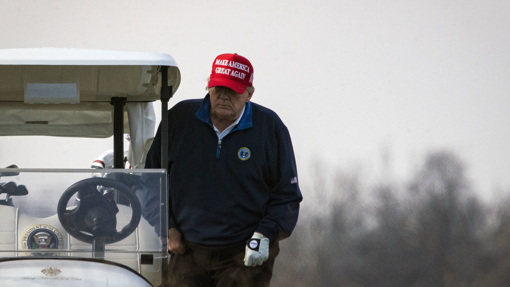 Donald Trump getting into a golf cart