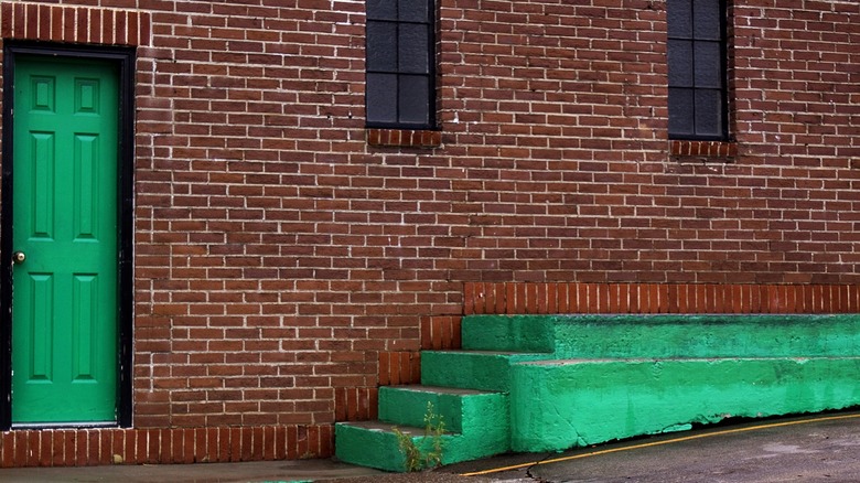 Green door in red brick wall