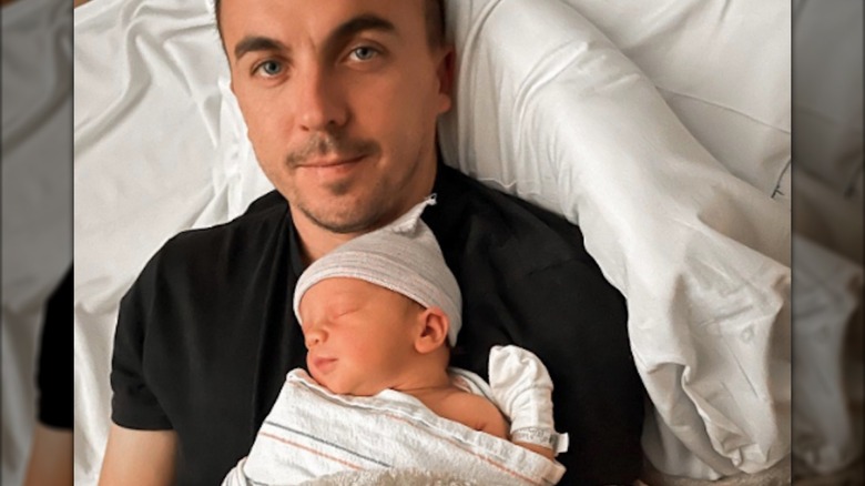 Frankie Muniz holding his newborn son