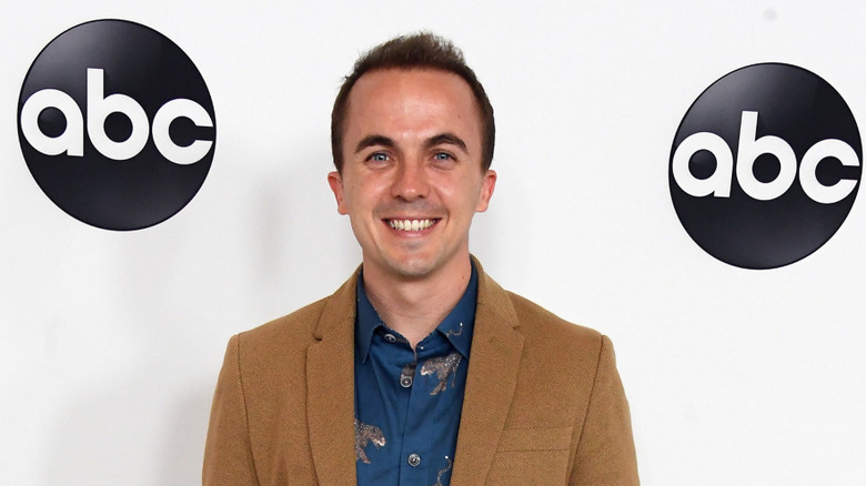 Frankie Muniz posing in front of ABC logos in 2018