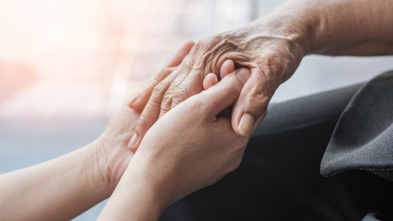 young hand holds old one