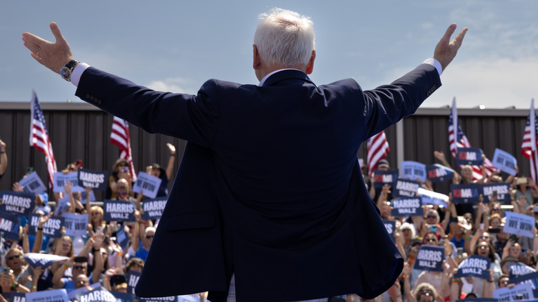 Tim Walz raising arms to crowd