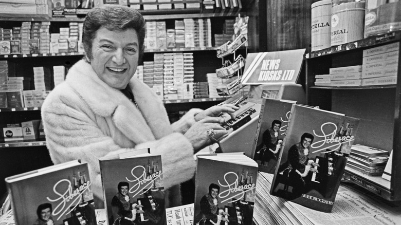 Liberace with his book