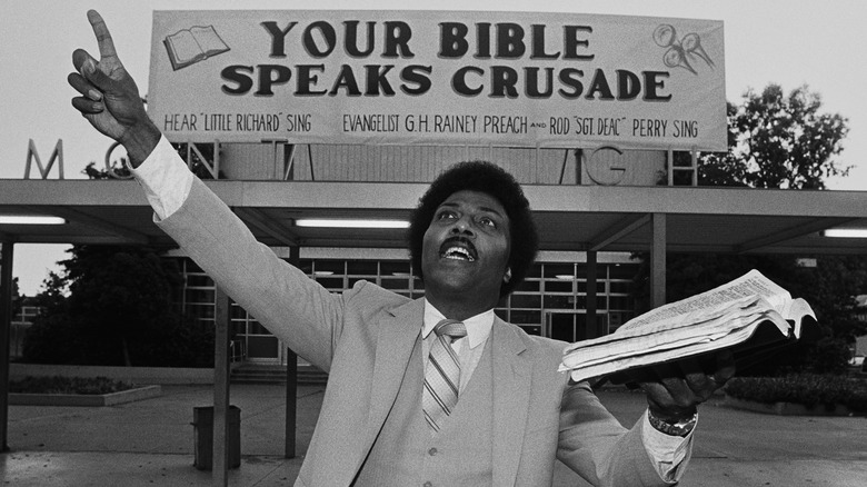 Little Richard lifting Bible while preaching