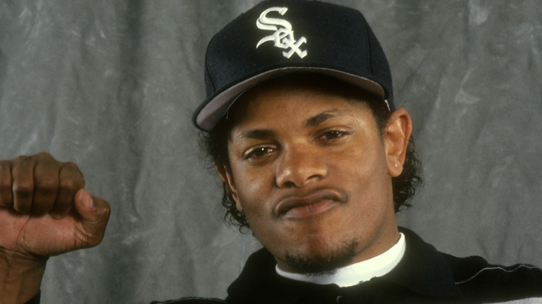 Eazy-E raising his fist in a White Sox hat