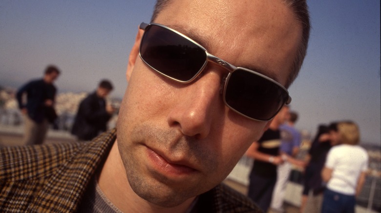 MCA in glasses with a blurry background of people