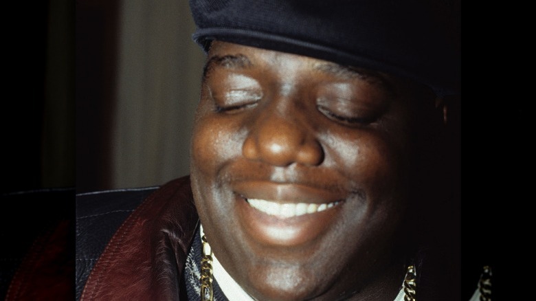 The Notorious B.I.G. smiling in a hat