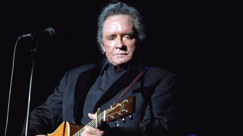 Johnny Cash playing guitar on stage 