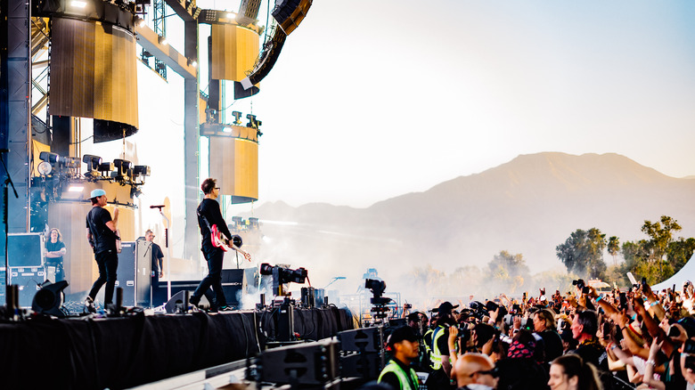 Tom Delonge and Mark hoppus on stage before crowd and mountains 2023