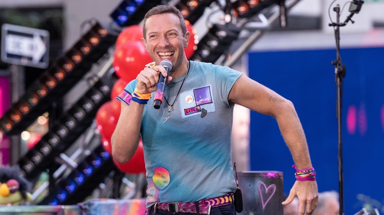 Tie-dyed Chris Martin singing on stage