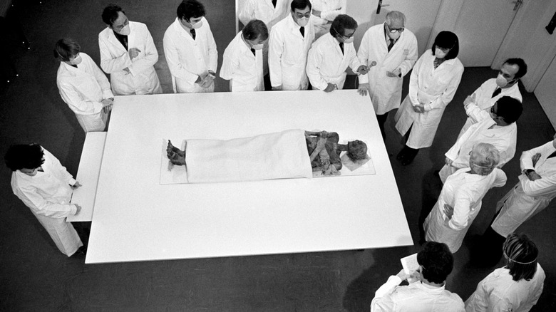 Ramses II mummy on table surrounded by doctors