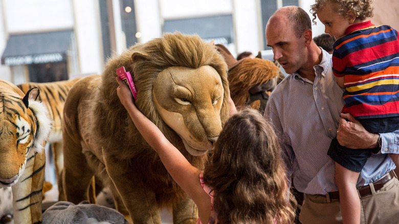 FAO Schwarz girl combing plush lion