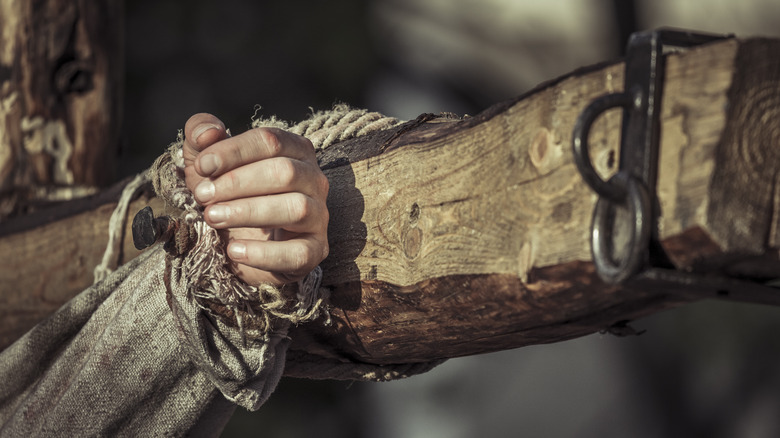 hand nailed to wooden cross