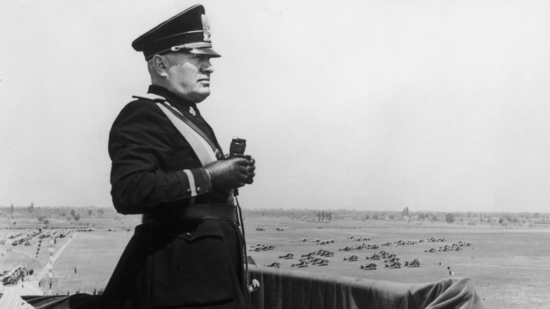 Benito Mussolini surveying field