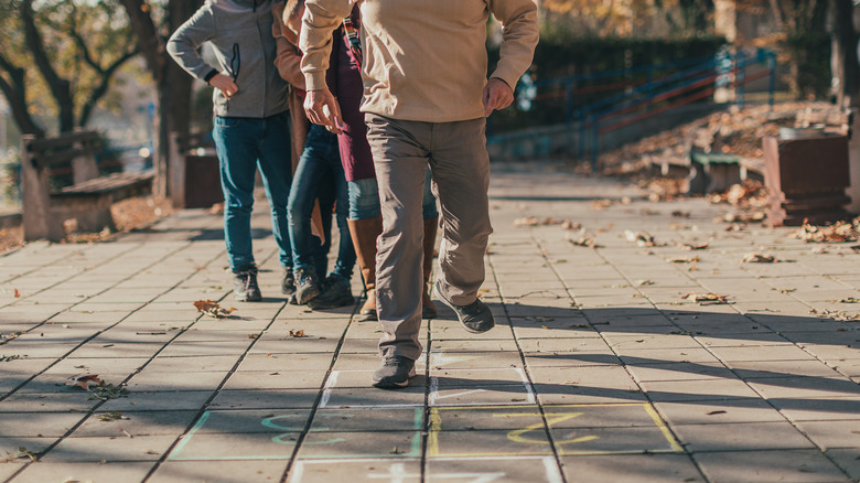 Elderly man playing hopscotch