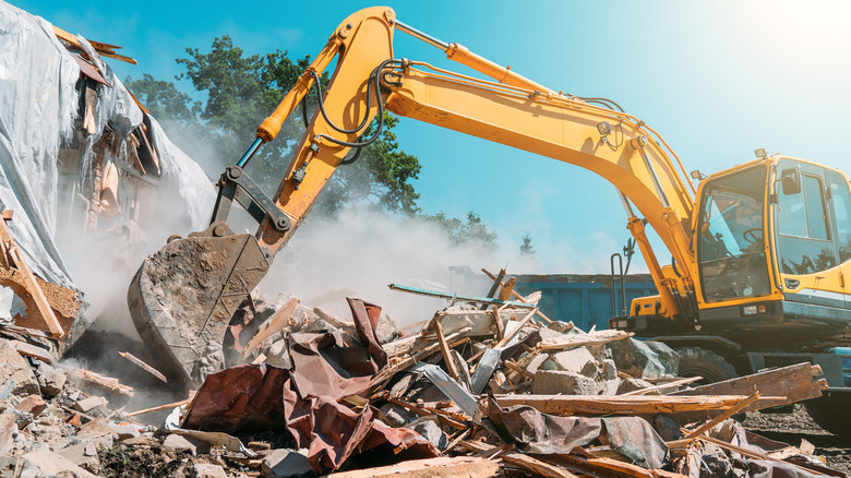 Demolition vehicle destroying building