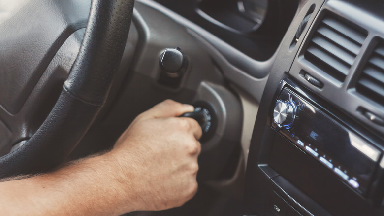 Person turning car key in ignition