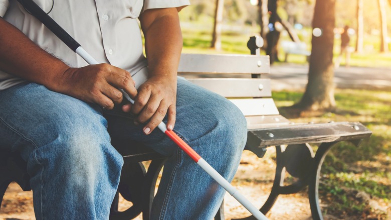 Sitting and holding a blind cane