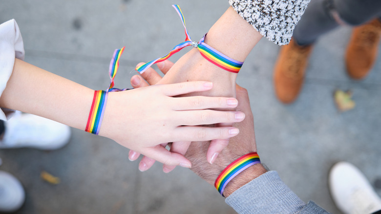 Hands with LGBT Pride bracelets