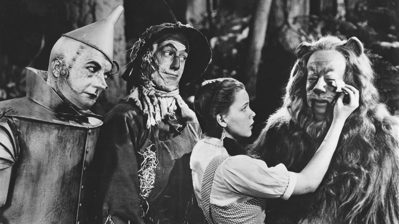 Dorothy wiping tear from cowardly lion's face in Wizard of Oz