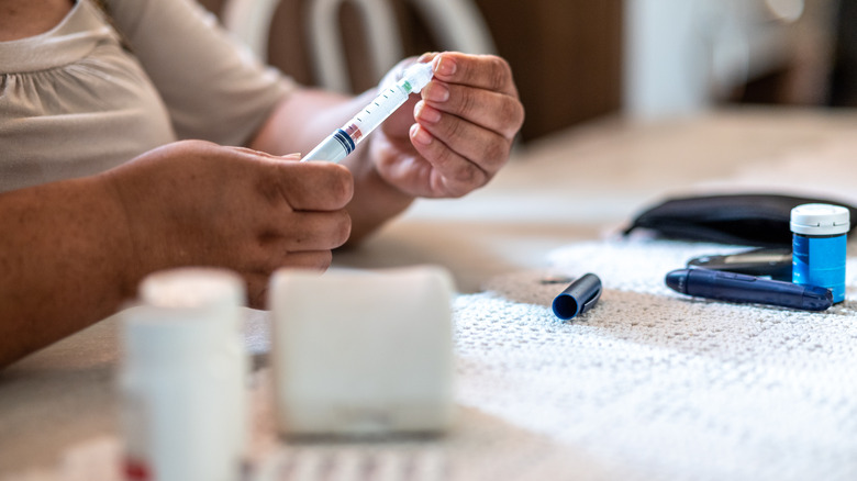 Person holding syringe table medication 