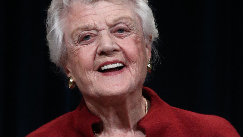 Angela Lansbury smiles in red