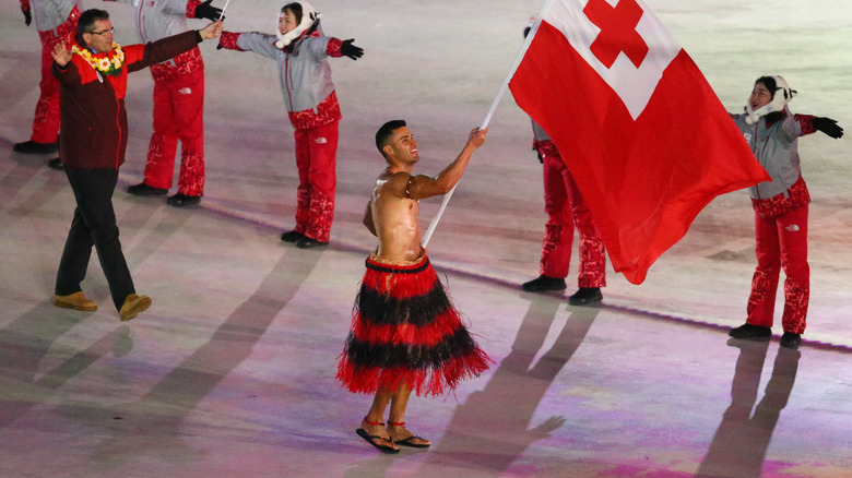 Pita Taufatofua bearing flag