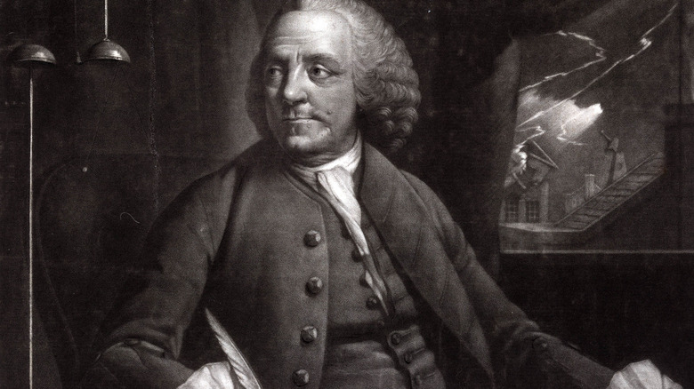 Benjamin Franklin sitting holding quill