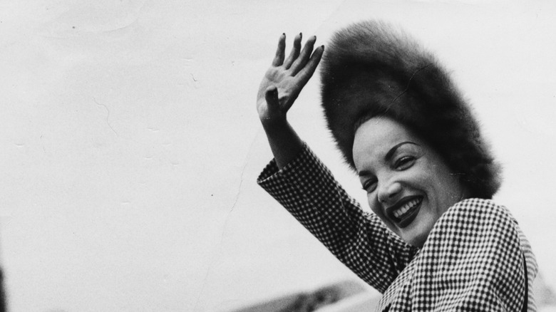 carmen miranda waving in a hat