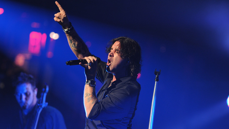 Scott Stapp pointing skyward while singing onstage