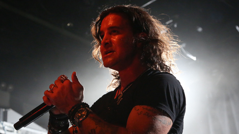 Scott Stapp backlit while performing onstage