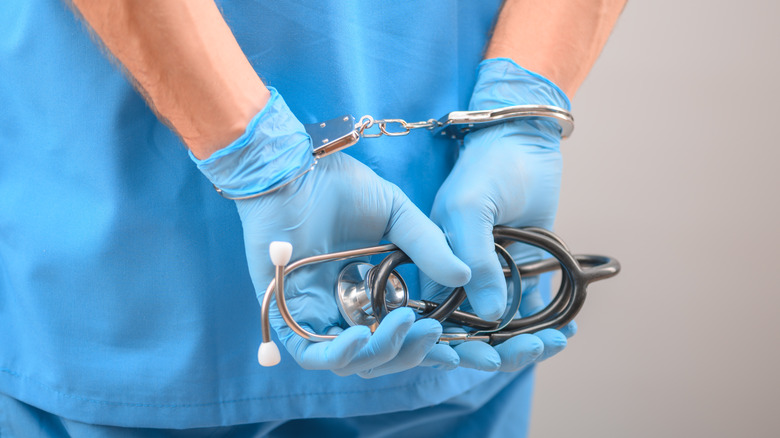 person in scrubs and handcuffs