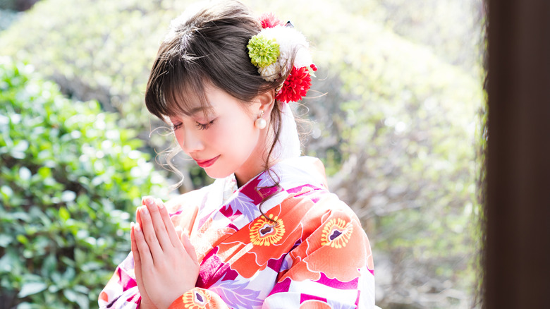 Woman praying at a Shinto shrine