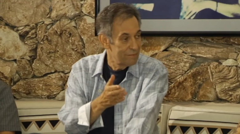 Larry Geller speaking in checked shirt