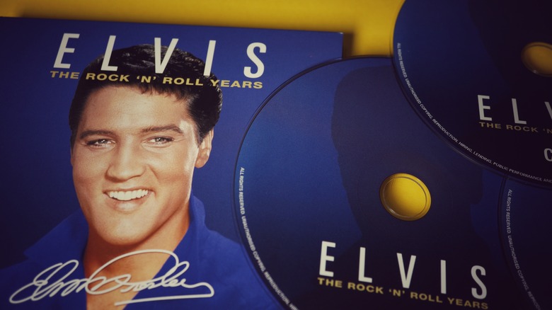 Elvis Presley smiling on album cover and CDs