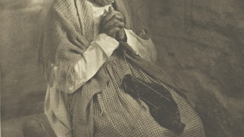 Woman praying while knitting