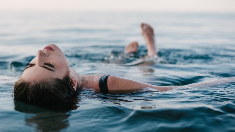 Woman floating on her back at sea