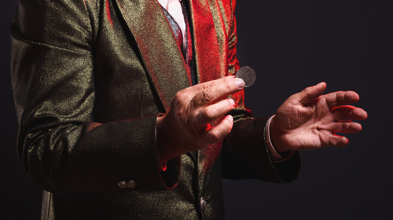 magician holding coin