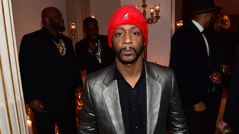 Katt Williams in red hat and silver suit