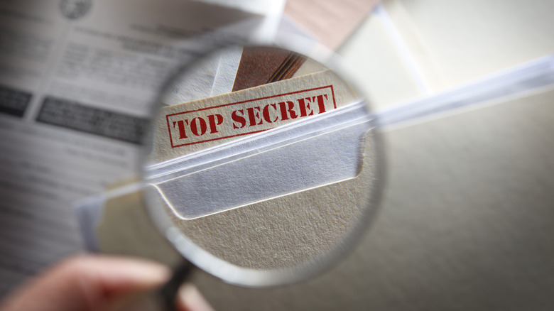 Magnifying glass over Top Secret folder