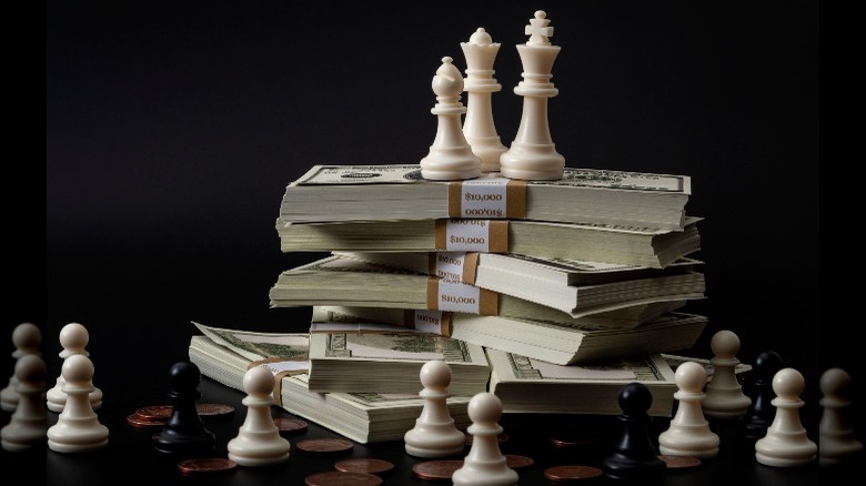 chess pieces and bundles of cash