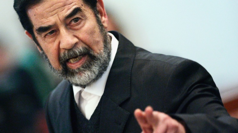 Saddam Hussein gesturing in court