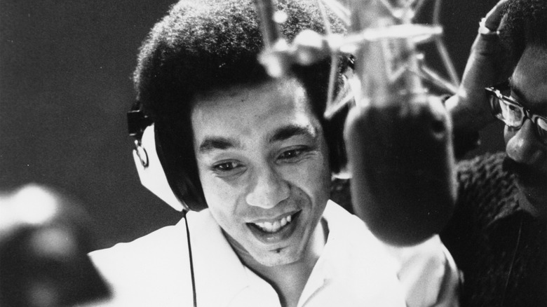 Smokey Robinson at a microphone in headphones