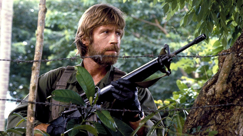 Chuck Norris carrying rifle