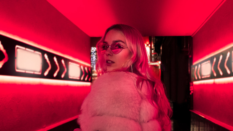 Girl in sunglasses in a red room