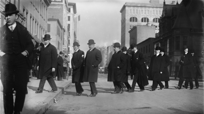 photo of the jury in the Thaw trial walking across the streeteach other in overcoats and bowlers hats, in black and white