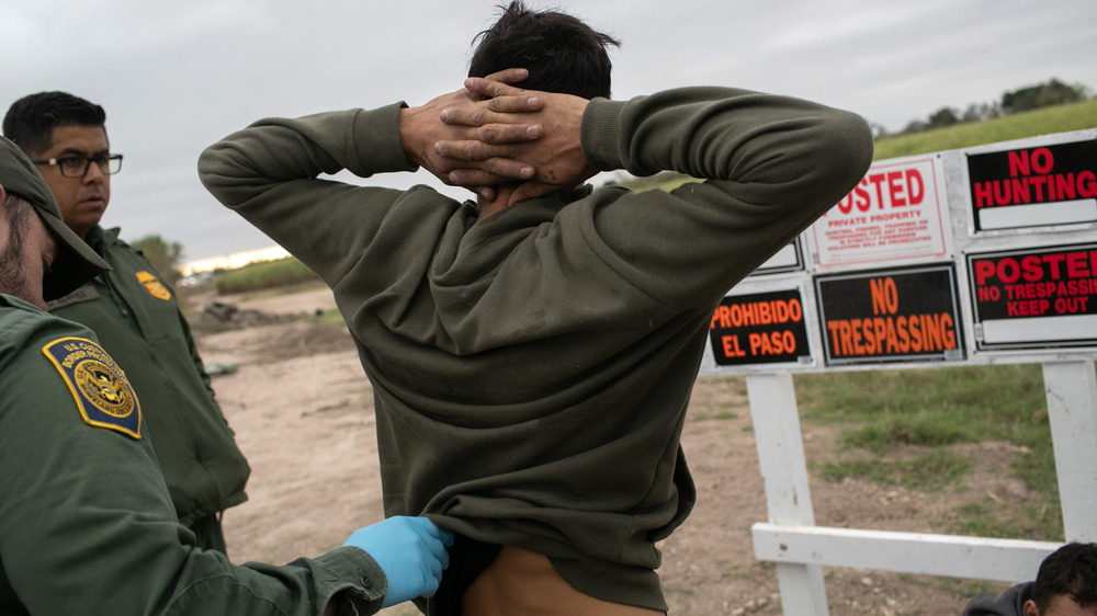 DECEMBER 11: U.S. Border Patrol agents detain undocumented immigrants caught near a section of privately-built border wall under construction on December 11, 2019 near Mission, Texas.