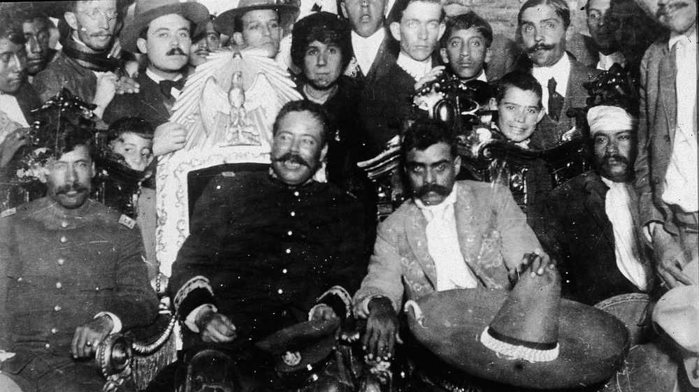 Emiliano Zapata (C, Left) (1879 - 1919) and Pancho Villa (1878 - 1923) (C, Right) sit in front of a group of soldiers, January 2, 1915. 